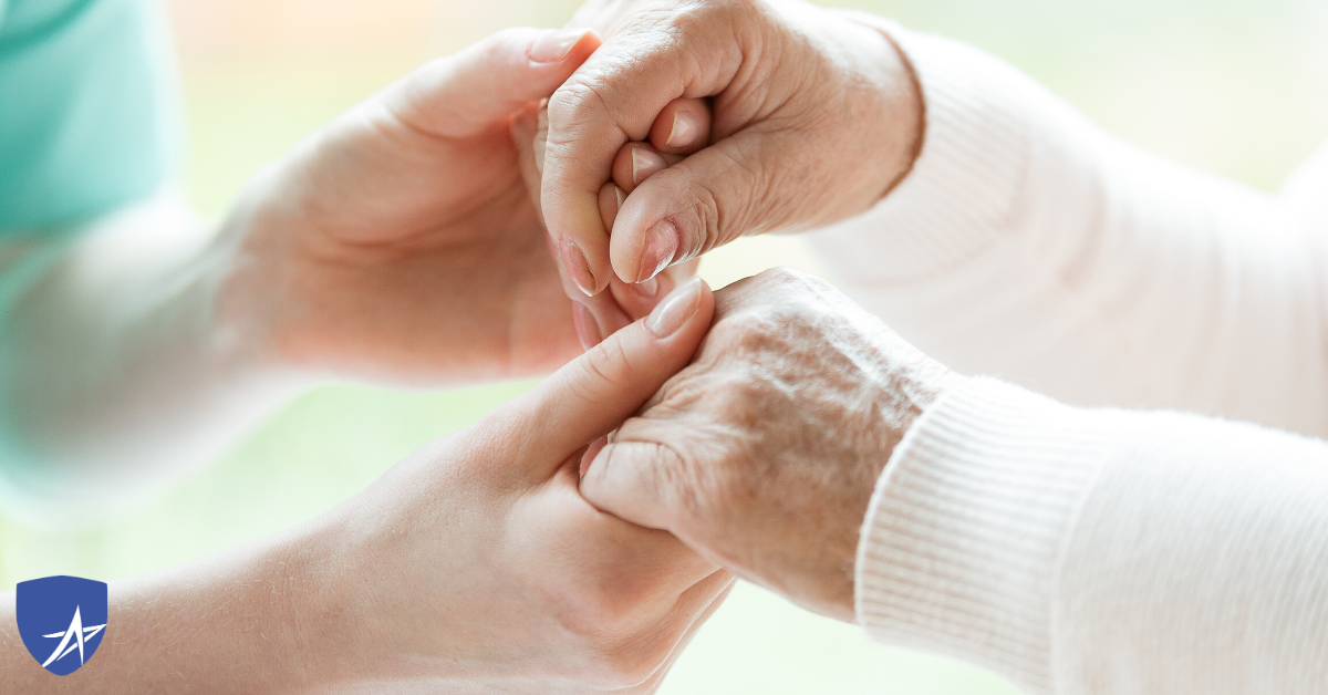 holding the hands of senior in hospice care