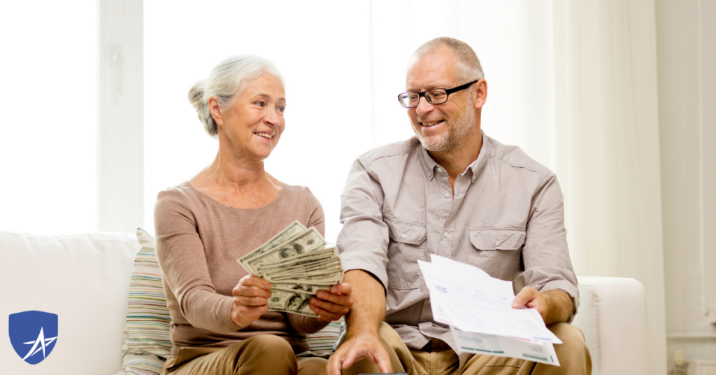 senior couple holding money smiling