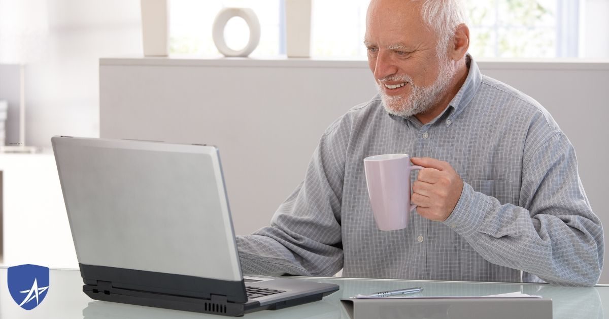 senior man drinking coffee at his computer